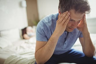 headaches a man with his hands on his face